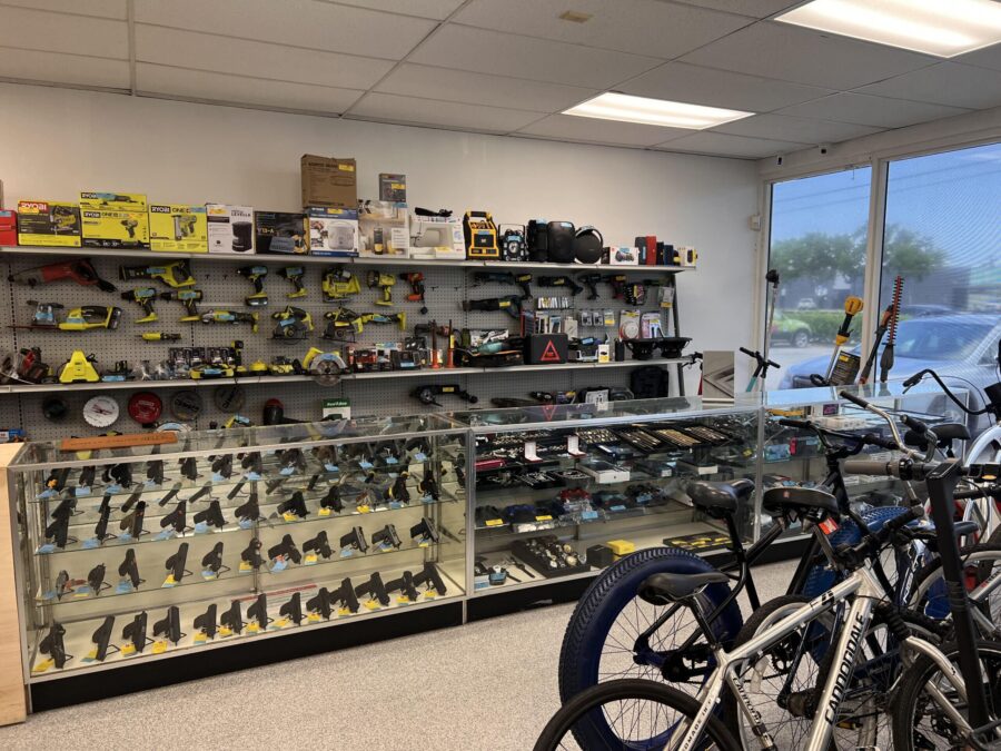 Interior of Dixie Pawn shop showcasing a variety of tools, firearms, electronics, and bicycles for sale and loans.