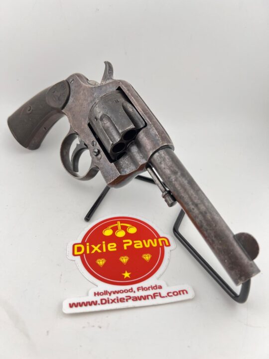 A vintage Colt D.A. 41 revolver with a rusted patina, displayed on a black stand. The image includes a Dixie Pawn sticker showcasing the store's logo, located in Hollywood, Florida, with the website www.DixiePawnFL.com.