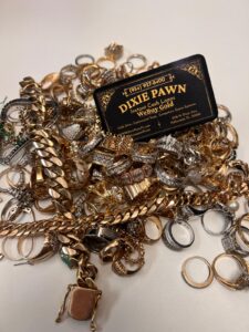 Pile of Real Gold jewelry & Dixie Pawn business card