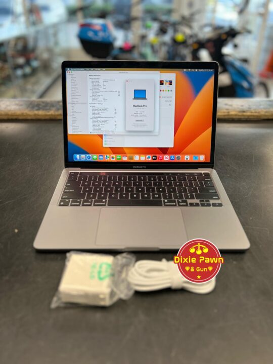 Apple MacBook Pro with charger displayed on a table, available at Dixie Pawn