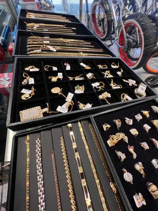 A display of gold necklaces, rings, and bracelets at Dixie Pawn in Hollywood, FL, showcasing the variety and quality of jewelry available for pawning or purchase.