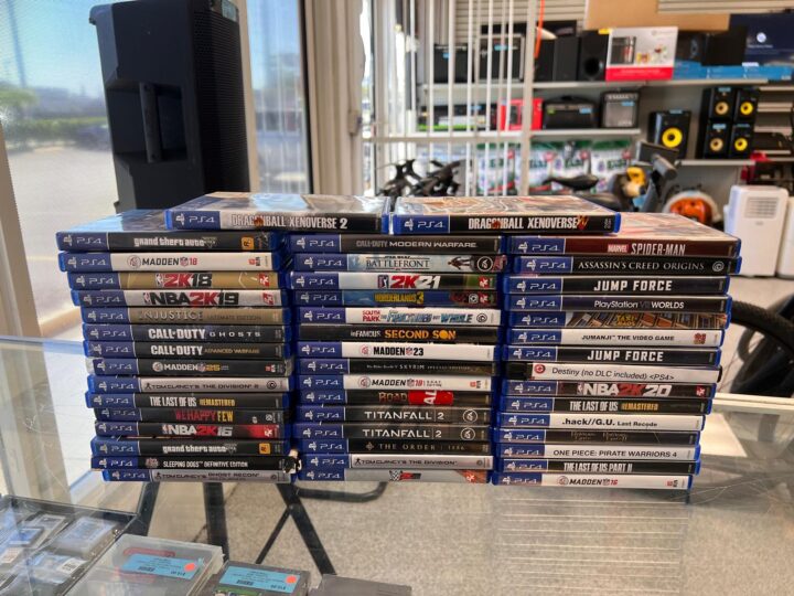 A neatly stacked pile of preowned PlayStation 4 games, showcasing a variety of titles available for purchase at Dixie Pawn in Hollywood, Florida.