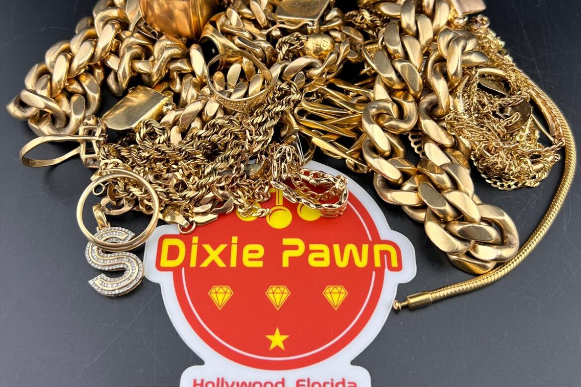 A collection of gold jewelry including chains, rings, and pendants with a Dixie Pawn branded sticker, located in Hollywood, Florida. Visit DixiePawnFL.com for gold buying and selling services.