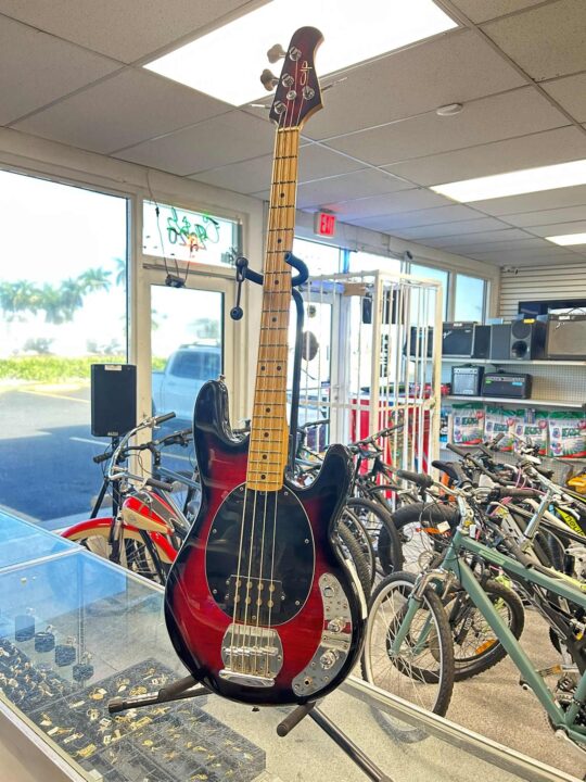 Vintage Style licensed StingRay-style bass guitar with sunburst finish on display at Dixie Pawn & Jewelry in Hollywood, Florida, featuring maple neck and classic humbucker pickup.